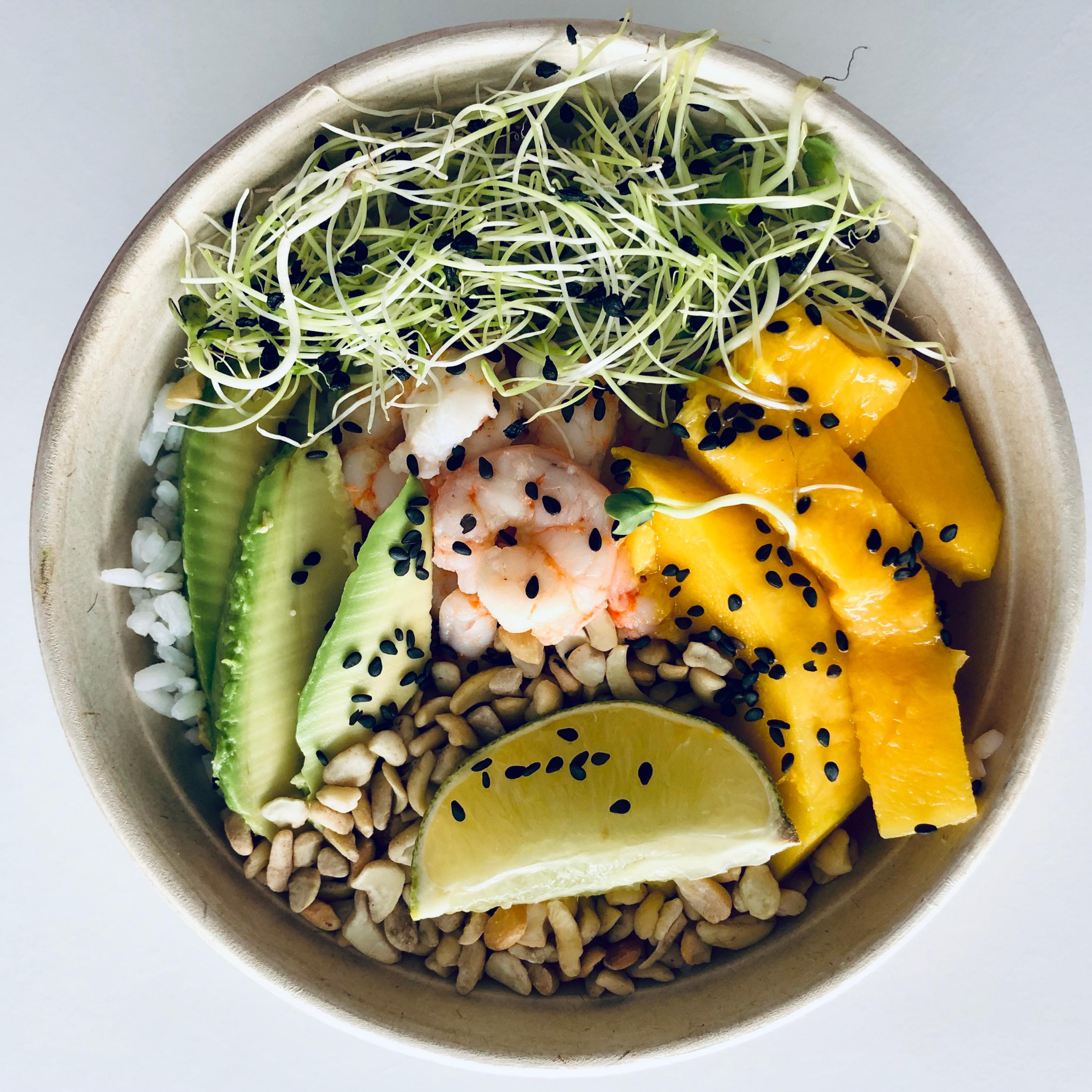 Bowl with mango, shrimp, rice, avocado, nuts, lime, sprouts with black seeds, represents “What’s Your Meal Prep Look Like” program